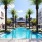 Large sparkling blue pool with a large pool deck and lounge chairs
